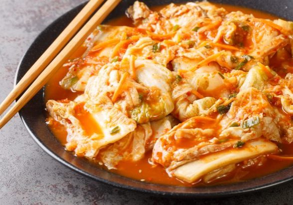 Close up Korean food, Kimchi cabbage in a black dish on a table. Horizontal